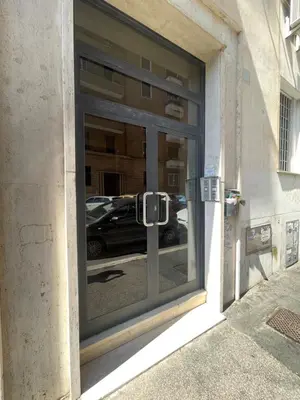 a window of a building with a reflection of a car in it at DOMUS I Cozy Apt -20 min from Colosseum in Rome