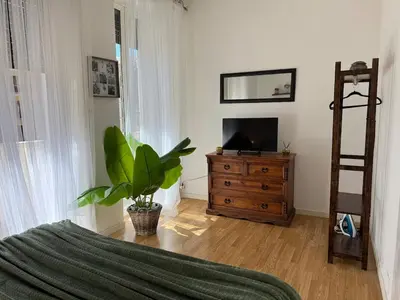 a living room with a television and a wooden dresser at DOMUS I Cozy Apt -20 min from Colosseum in Rome