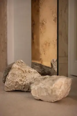 two rocks sitting on the floor next to a mirror at Nomos Hotel in Rome