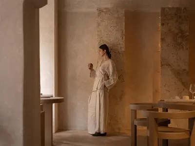 a woman in a white robe standing in a room at Nomos Hotel in Rome