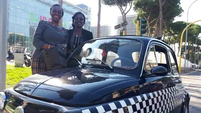 two women are standing next to a car at B&B Il Giardino di Gabri in Rome
