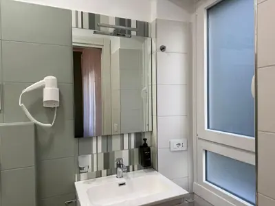 a bathroom with a sink and a mirror at Nella House Roma in Rome