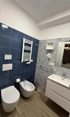 a bathroom with a white toilet and a sink at Nella House Roma in Rome