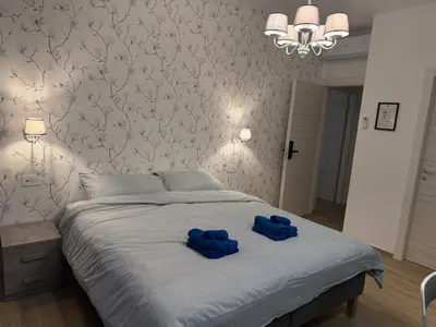 a bedroom with a bed with two blue slippers on it at Nella House Roma in Rome