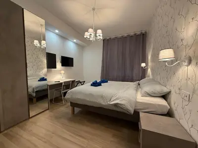 a bedroom with a bed and a desk and a mirror at Nella House Roma in Rome