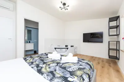 a white bedroom with a bed and a tv at Termini Roma Imperiale in Rome