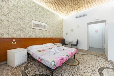 a hotel room with a bed and a table and chairs at Termini Roma Imperiale in Rome