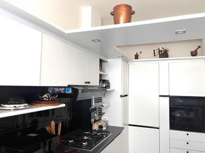 a kitchen with white cabinets and a black stove top oven at Roma San Pietro - Elegante appartamento con vista in Rome