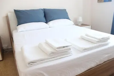 a bed with white towels stacked on top of it at Relais Monteverde in Rome