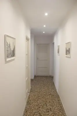 a hallway with white walls and paintings on the walls at Relais Monteverde in Rome