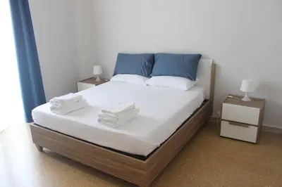 a bed with blue and white sheets and pillows at Relais Monteverde in Rome