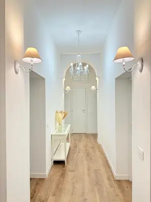 a hallway with a table and two chandeliers at Seiemme Colosseo Luxury Apartment 2 in Rome