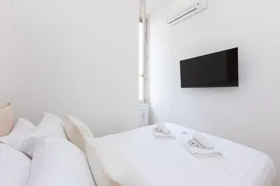 a white room with a couch and a tv at Mellini View by Rental in Rome in Rome