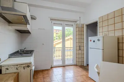 a kitchen with a white refrigerator and a window at Star Guest House Rome in Rome