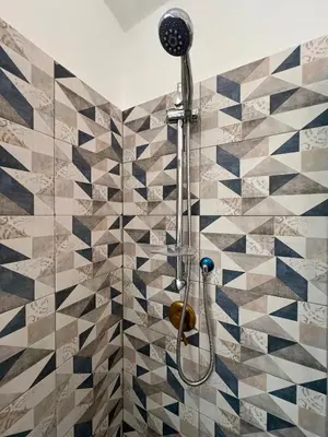 a shower in a bathroom with a tiled wall at Spagna Home in Rome