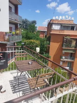a table and chairs on a balcony with a building at Roma San Pietro alloggio turistico Casa Patrizia in Rome