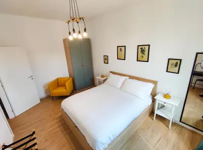 a bedroom with a white bed and a yellow chair at Re di Room in Rome