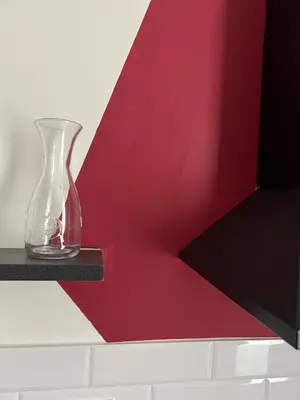 a glass vase sitting on a ledge next to a red wall at Quattro fiori apartment in Rome