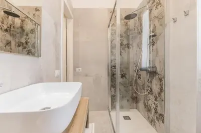 a white bathroom with a sink and a shower at Urbano 29 apartment in Rome