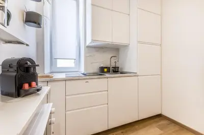 a white kitchen with white cabinets and a window at Urbano 29 apartment in Rome