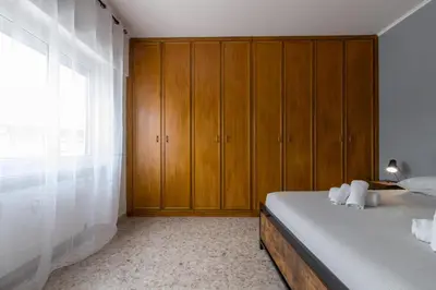 a bedroom with a bed with wooden cabinets and a window at Katia House in Rome