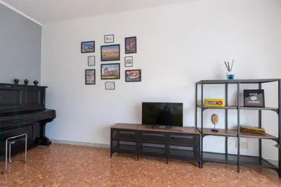 a living room with a piano and a television on a wall at Katia House in Rome
