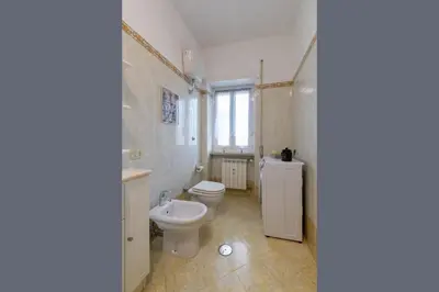 a white bathroom with a toilet and a sink at Katia House in Rome