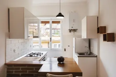 a kitchen with white cabinets and a counter top at Maison 46 in Rome