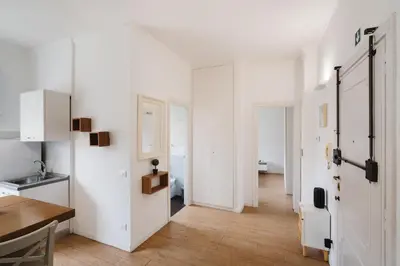 a kitchen with white walls and a wooden floor at Maison 46 in Rome
