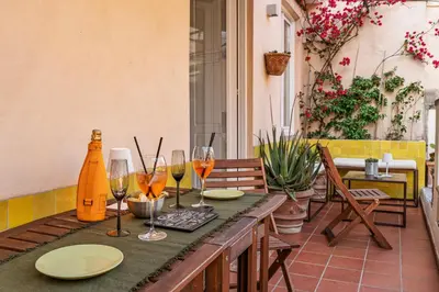 a table with glasses of wine on a patio at Giulia's House, Monti in Rome