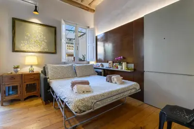 a bedroom with a bed and a desk and a refrigerator at Giulia's House, Monti in Rome