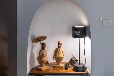 a table with two statues and a lamp on it at Giulia's House, Monti in Rome