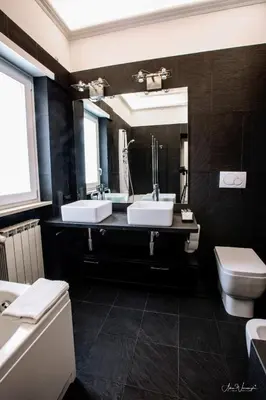 a bathroom with two sinks and a toilet and a mirror at Magikrooms Domus in Rome