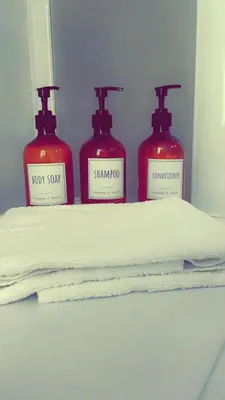 three bottles of soap sitting on top of a shelf at All Suite Colosseo in Rome