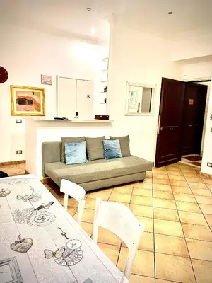 a living room with a couch and a table and chairs at All Suite Colosseo in Rome