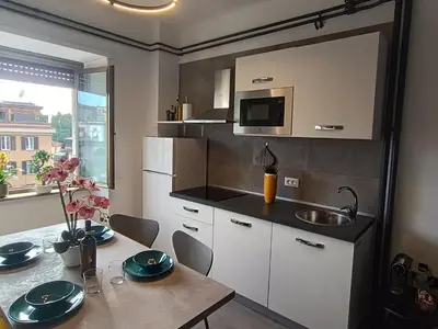 a small kitchen with a table and a sink at Casa Vacanze Bianca - Metro A - Furio Camillo in Rome
