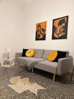 a living room with a gray couch and two pictures at Luxury Apartment in Prati in Rome