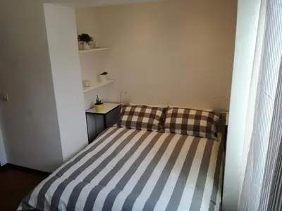 a small bedroom with a striped bed in a room at Bikehouse in Rome