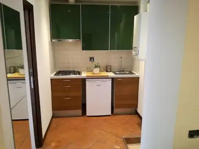 a kitchen with green cabinets and a white dishwasher at Bikehouse in Rome