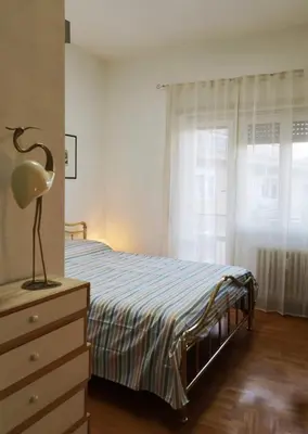 a bedroom with a bed and a dresser and a window at large Vatican loft near the metro in Rome