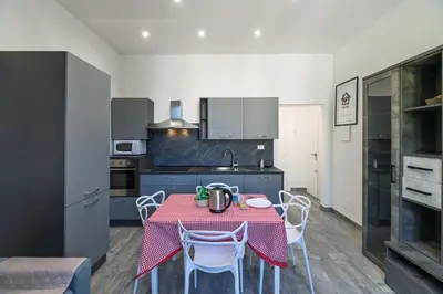 a kitchen with a table and chairs in a room at Rooma Roman Nest Garbatella - metro B line in Rome