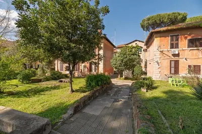 a stone path in front of a house with a tree at Rooma Roman Nest Garbatella - metro B line in Rome