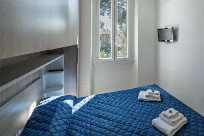 a bedroom with a blue bed with towels on it at Rooma Roman Nest Garbatella - metro B line in Rome