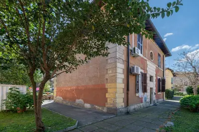 a building with a tree next to a sidewalk at Rooma Roman Nest Garbatella - metro B line in Rome