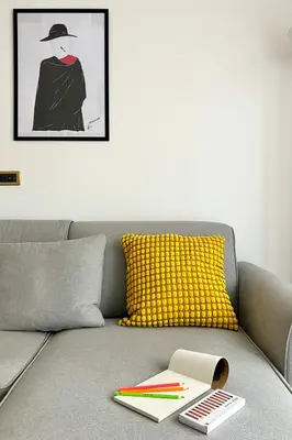 a living room with a gray couch with a yellow pillow at The Roman Sketchpad, Few Steps from Villa Borghese in Rome