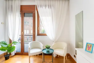 a living room with two chairs and a table and a window at The Roman Sketchpad, Few Steps from Villa Borghese in Rome