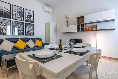 a dining room with a table and a blue couch at Haven25 in Rome