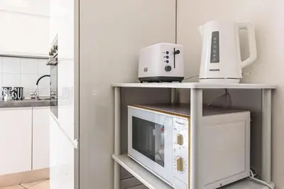 a kitchen with a microwave and appliances on a shelf at Haven25 in Rome