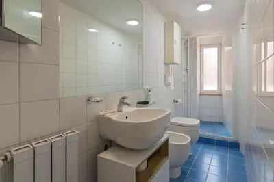 a white bathroom with a sink and a toilet at Haven25 in Rome