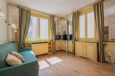 a living room with a blue couch and some windows at Roman Forum apartament in Rome